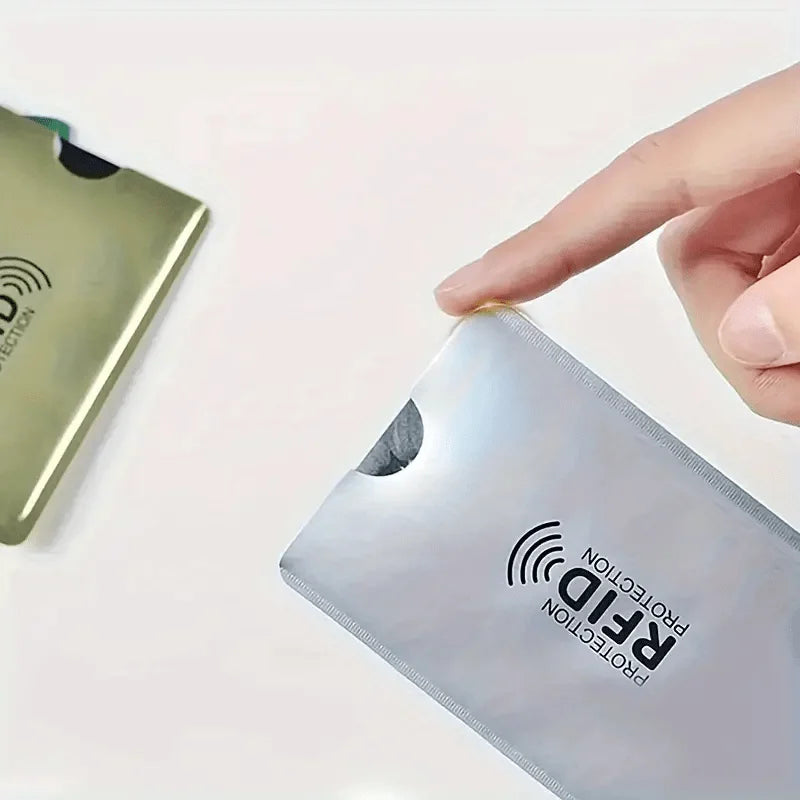 A hand is placing an RFID protection card sleeve onto a plastic card.