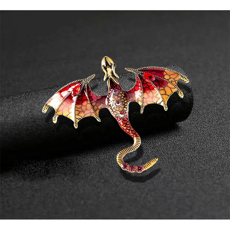 An enamel dragon brooch featuring iridescent red and orange scales with rhinestone accents.