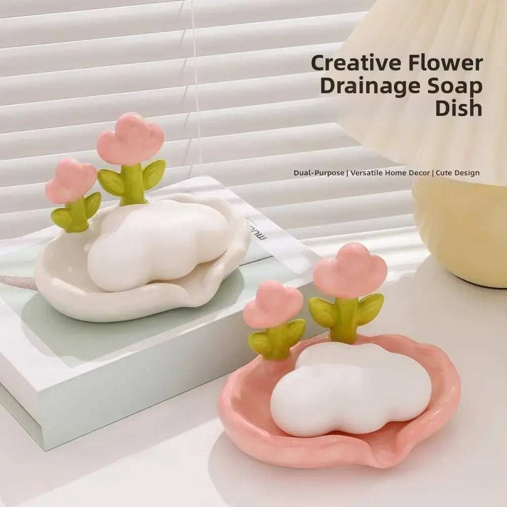 A pink tulip drainage soap dish with a white cloud design is displayed on a light surface.