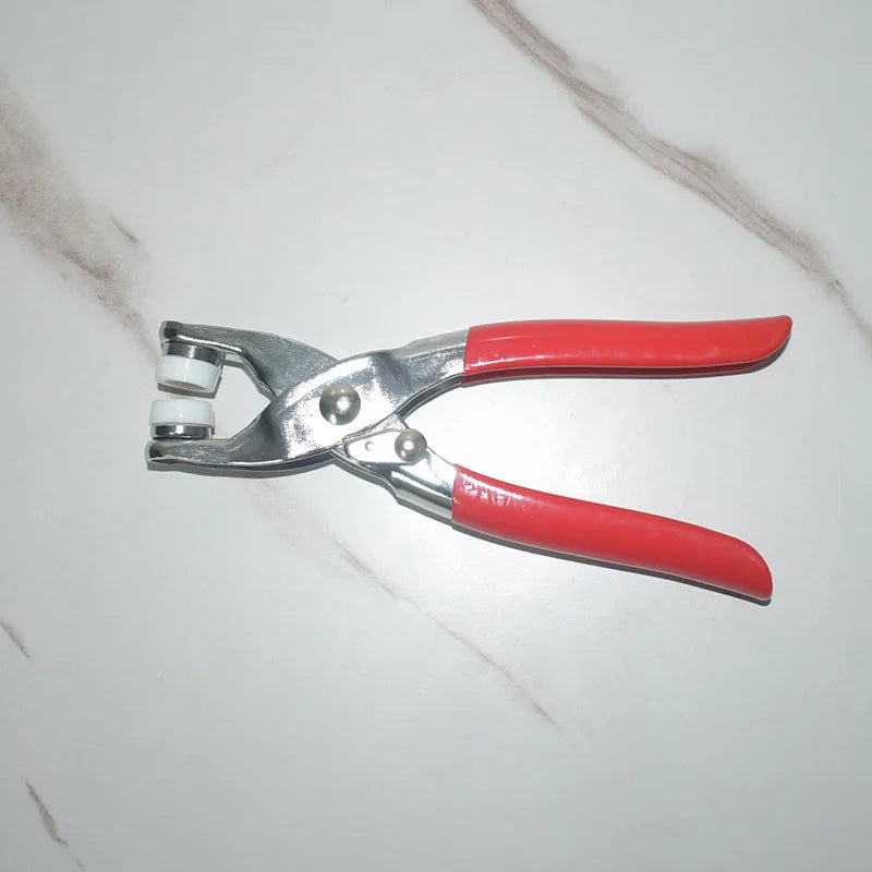 A pair of silver metal snap buttons with red handles for clothing, bags, and DIY crafts.