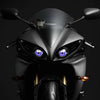 A close-up view of a black motorcycle headlight with blue LED eyes and remote control features.
