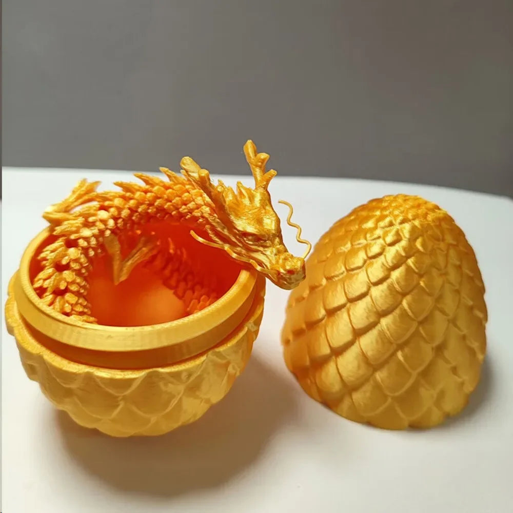 A golden dragon figurine with a glowing orange egg inside, displayed on a white surface.