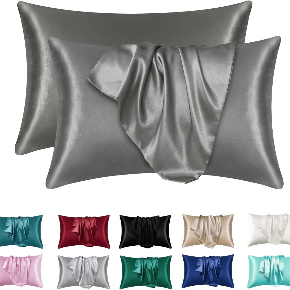 Un juego de fundas de almohada de seda satinada en varios tonos, incluyendo coral, gris y azul.