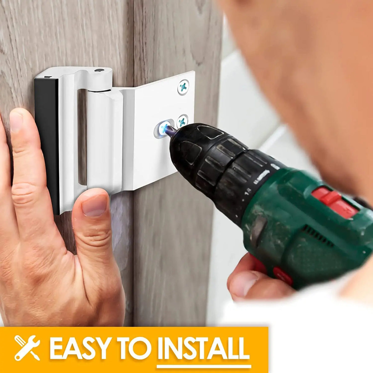 A hand is installing a heavy duty aluminum door lock onto a wooden door frame using a power drill.