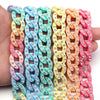 A hand holds a set of 20 acrylic jewelry connector clasps in various pastel colors like blue, green, yellow, and pink.