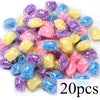 A collection of colorful water-soluble laundry fragrance beads in various shades of purple, blue, and yellow.