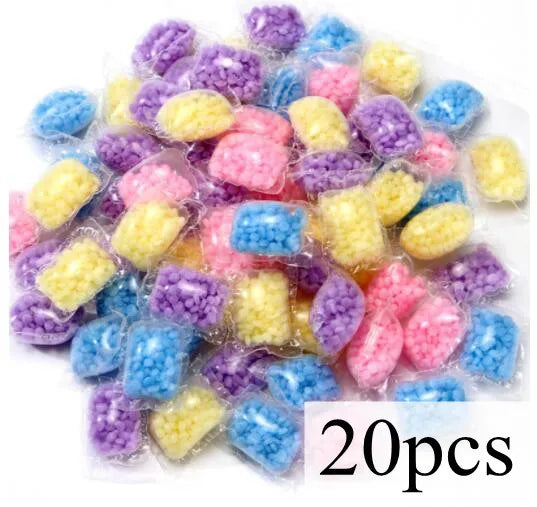 A collection of colorful water-soluble laundry fragrance beads in various shades of purple, blue, and yellow.