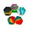 A collection of colorful hexagonal silicone travel jars for creams and balms in shades of green, purple, yellow, and blue.