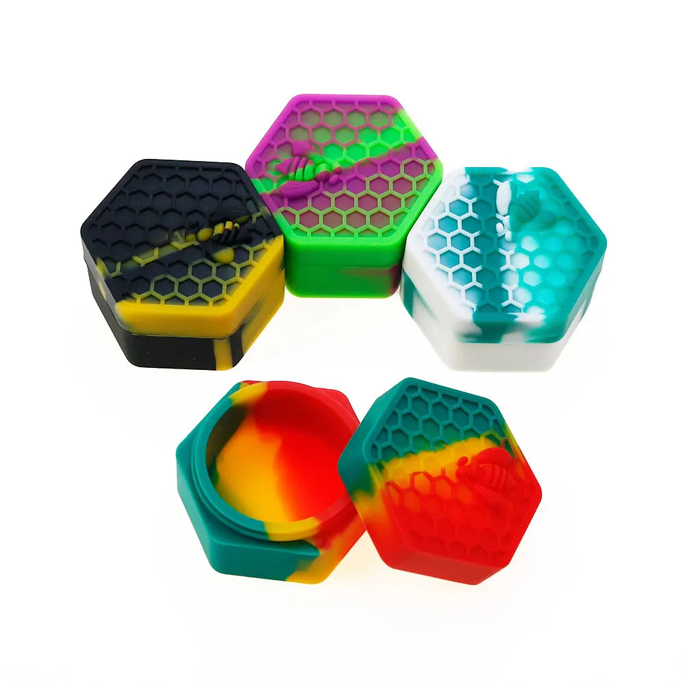 A collection of colorful hexagonal silicone travel jars for creams and balms in shades of green, purple, yellow, and blue.