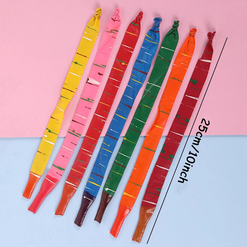 A collection of 10 colored whistling flying party balloons arranged diagonally on a pink and blue background.