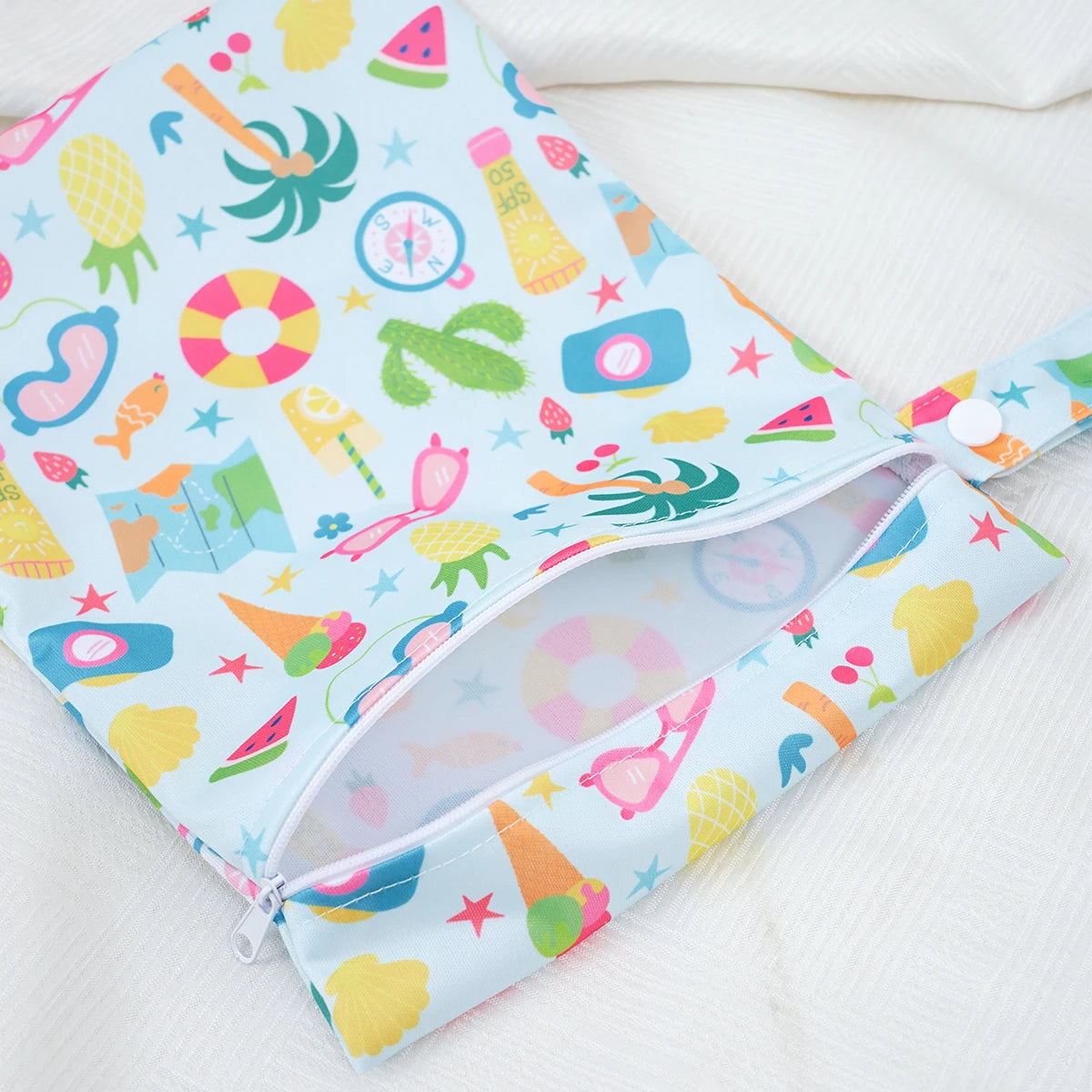 A light blue patterned mini waterproof wet dry bag for baby, featuring fruit and colorful designs.