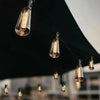 String lights featuring vintage Edison bulbs hanging under a dark awning.
