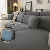 Asiento de sofá gris elástico y funda de cojín mostrados en un sofá con cojines decorativos y una manta.