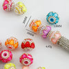 A collection of colorful rhinestone round beads and a finished beaded bracelet for jewelry making.
