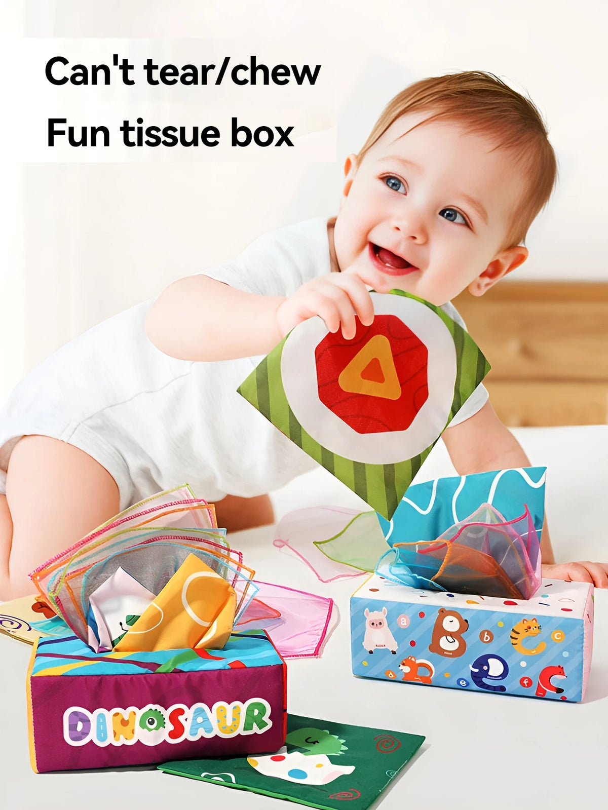 A baby is shown interacting with a fun tissue box filled with colorful cloth book rings and toys.
