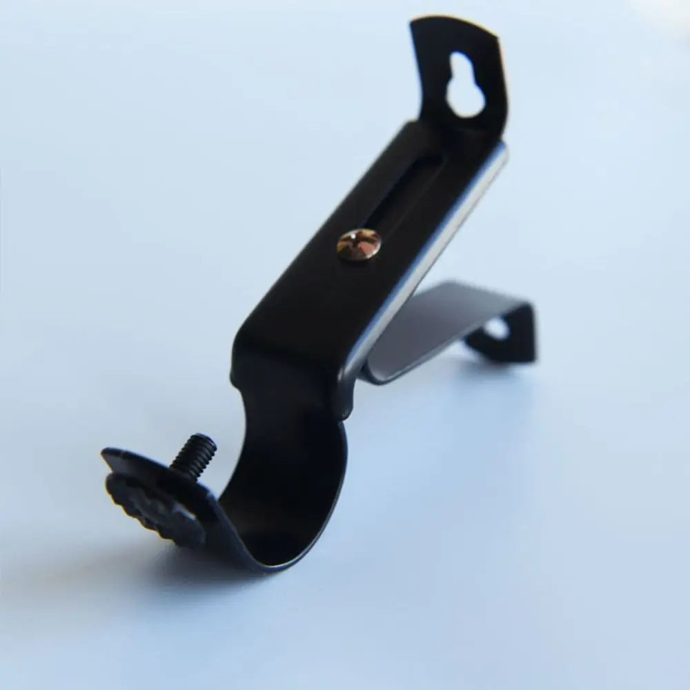A black no-drill metal curtain rod bracket with an adjustable wall mount support.