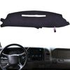 Black custom-fit dashboard cover for a truck or SUV shown resting on a steering wheel.