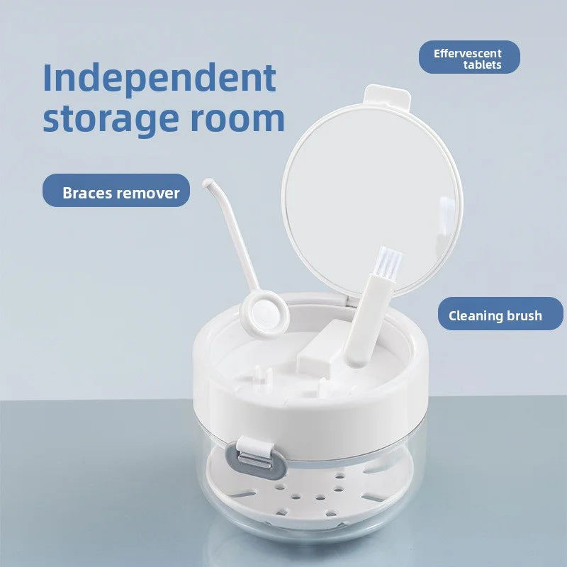 A white portable retainer and denture cleaning case with an open lid showing a cleaning brush and space for effervescent tabl