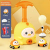 A yellow balloon-powered racing car toy is shown with an orange air pump and a small white toy.