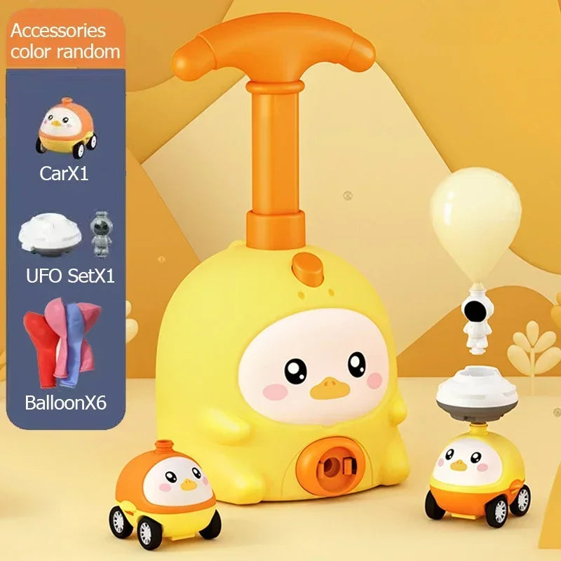 A yellow balloon-powered racing car toy is shown with an orange air pump and a small white toy.