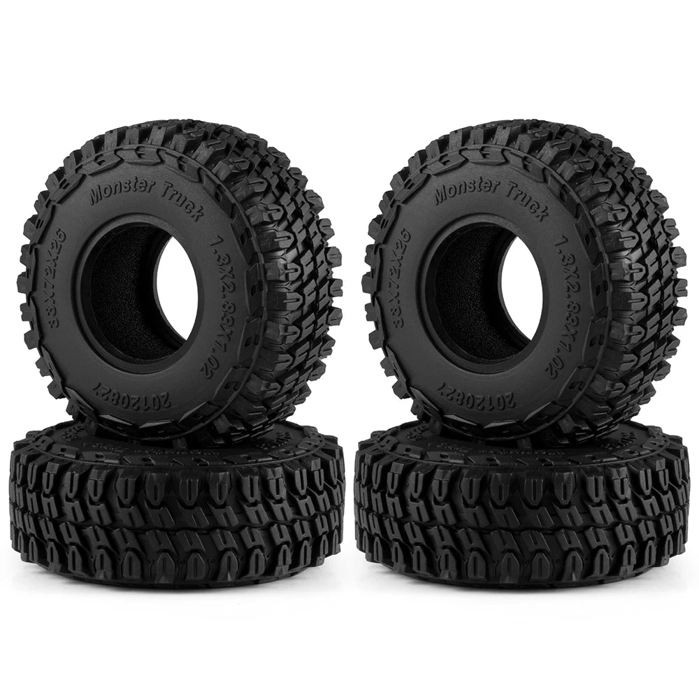 A set of four black Monster Truck mud terrain rubber tires for RC crawlers.