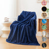 A deep blue, fluffy brushed flannel throw blanket draped over a chair in a bright room.