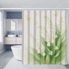 A beige floral shower curtain featuring green leaves and white flowers hanging in a bathroom.