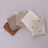 A collection of soft cotton gauze burp cloths in beige and brown tones with ties.