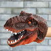 A realistic dinosaur hand puppet toy with textured brown skin and sharp teeth is shown against a gray brick background.