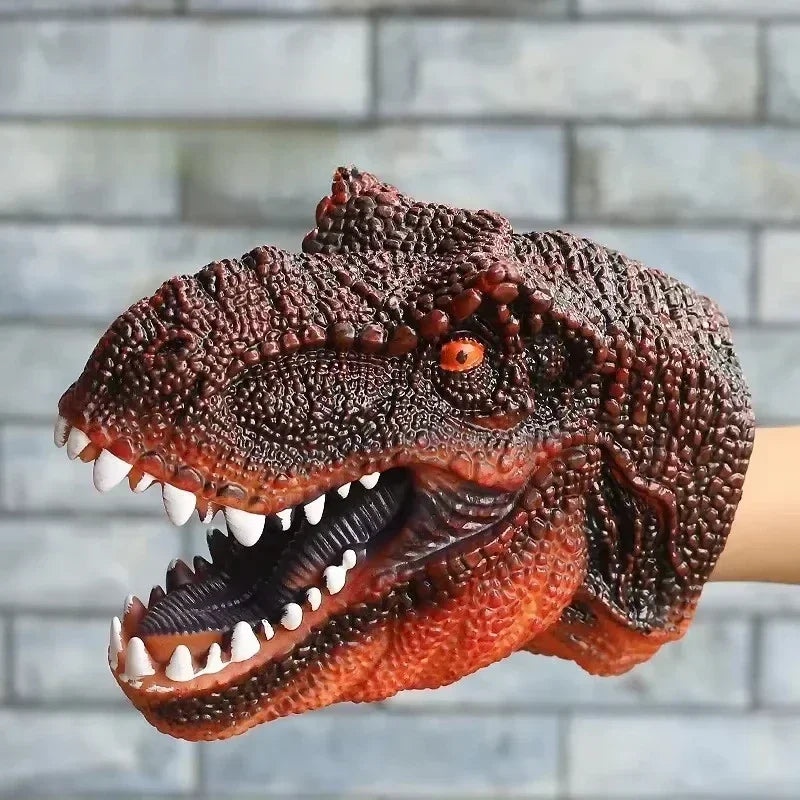 A realistic dinosaur hand puppet toy with textured brown skin and sharp teeth is shown against a gray brick background.