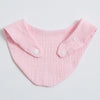A pink organic cotton muslin baby bib with a gathered collar and buttons.