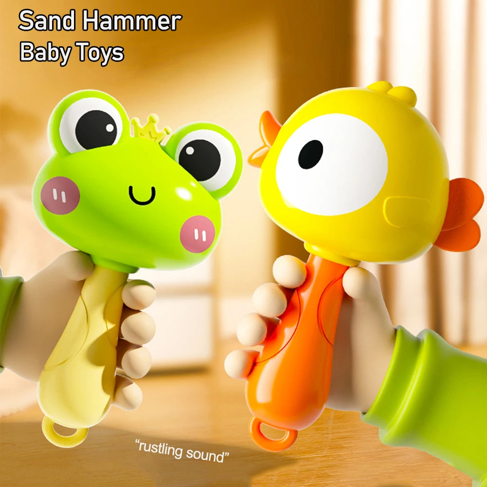 A hand is holding a yellow cartoon animal rattle toy with a green frog head and orange body.