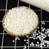 A golden bowl filled with white soy wax granules, set against a black and white checkered background.