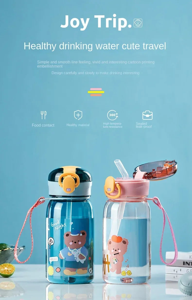 A clear glass water bottle with a pink lid and straw, featuring a cute bear design, set against a light blue background.