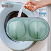 A hand is placing a mesh laundry bag for delicates into a washing machine drum.