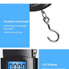 Close-up of a portable digital luggage scale showing a 0.000 reading and a finished steel hook detail.