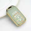 A light green TPU protective key case with gold accents resting on a white surface.