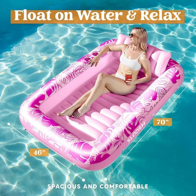 Un transat de piscine gonflable rose flotte sur l'eau, avec une femme qui se détend dedans.