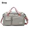 A grey waterproof travel duffle bag with a shoe compartment and pink straps.