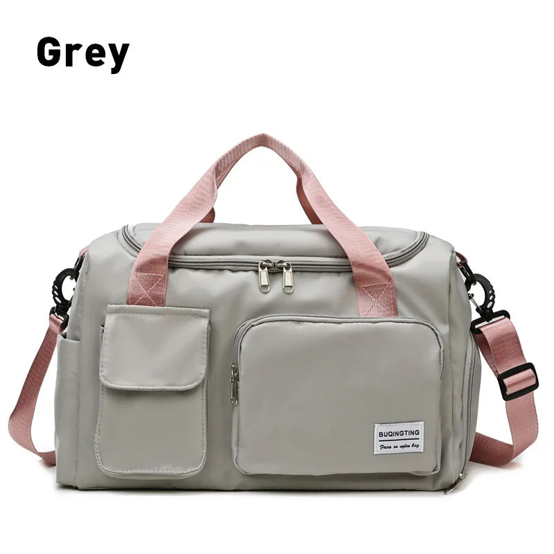 A grey waterproof travel duffle bag with a shoe compartment and pink straps.