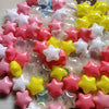 A collection of colorful, non-toxic star-shaped ball pit balls in pink, white, yellow, and red for children.