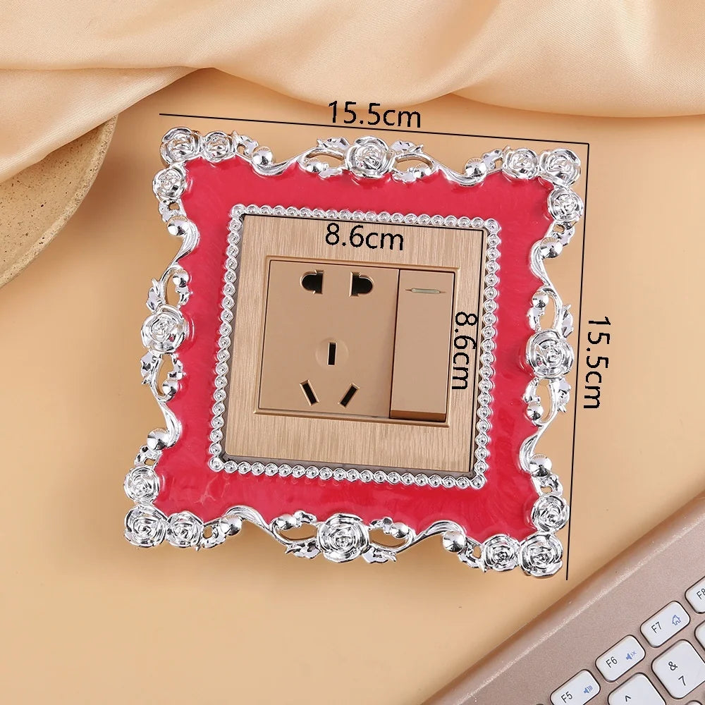 A rectangular switch cover frame with a rose pattern border and gold accents, shown against a light background.