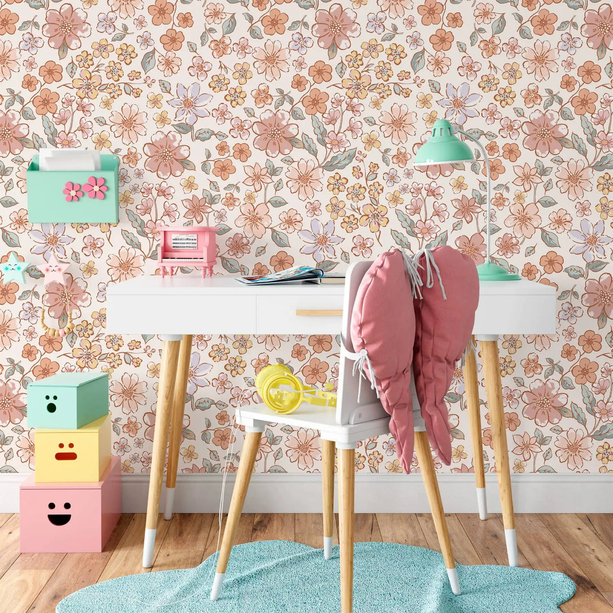 A white table with a pink chair and accessories set against a vintage floral peel-and-stick wallpaper background.