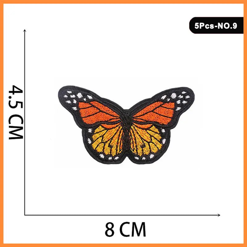 A black butterfly patch with orange and yellow embroidery on a white background.