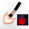 A heart-shaped car handle decor featuring a holographic finish attached to a black strap.