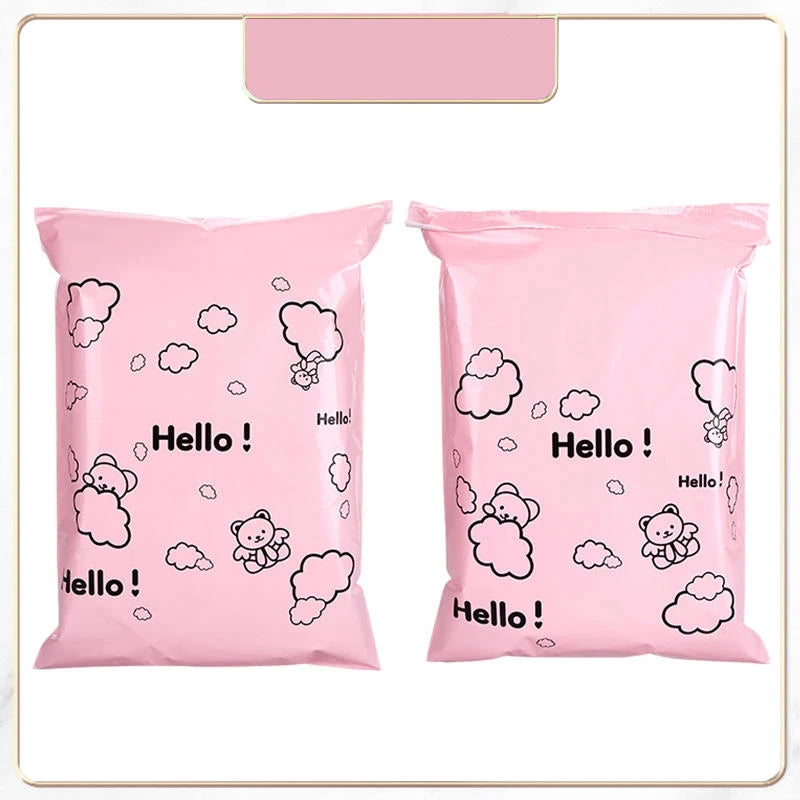 Two pink self-sealing mailing bags featuring a white outline of a bear and clouds.