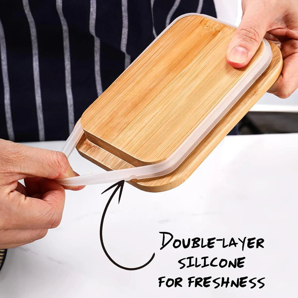 A hand is holding a double-layer silicone food container with a wooden lid and a stainless steel knife for freshness.