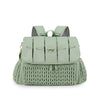 A light sage green waterproof diaper bag with mesh shoulder straps and a textured knit bottom.