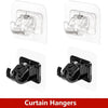 A set of two black no-drill adhesive curtain rod brackets for mounting curtains.