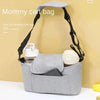 A grey mommy cart bag with a cup holder is displayed against a light yellow background.